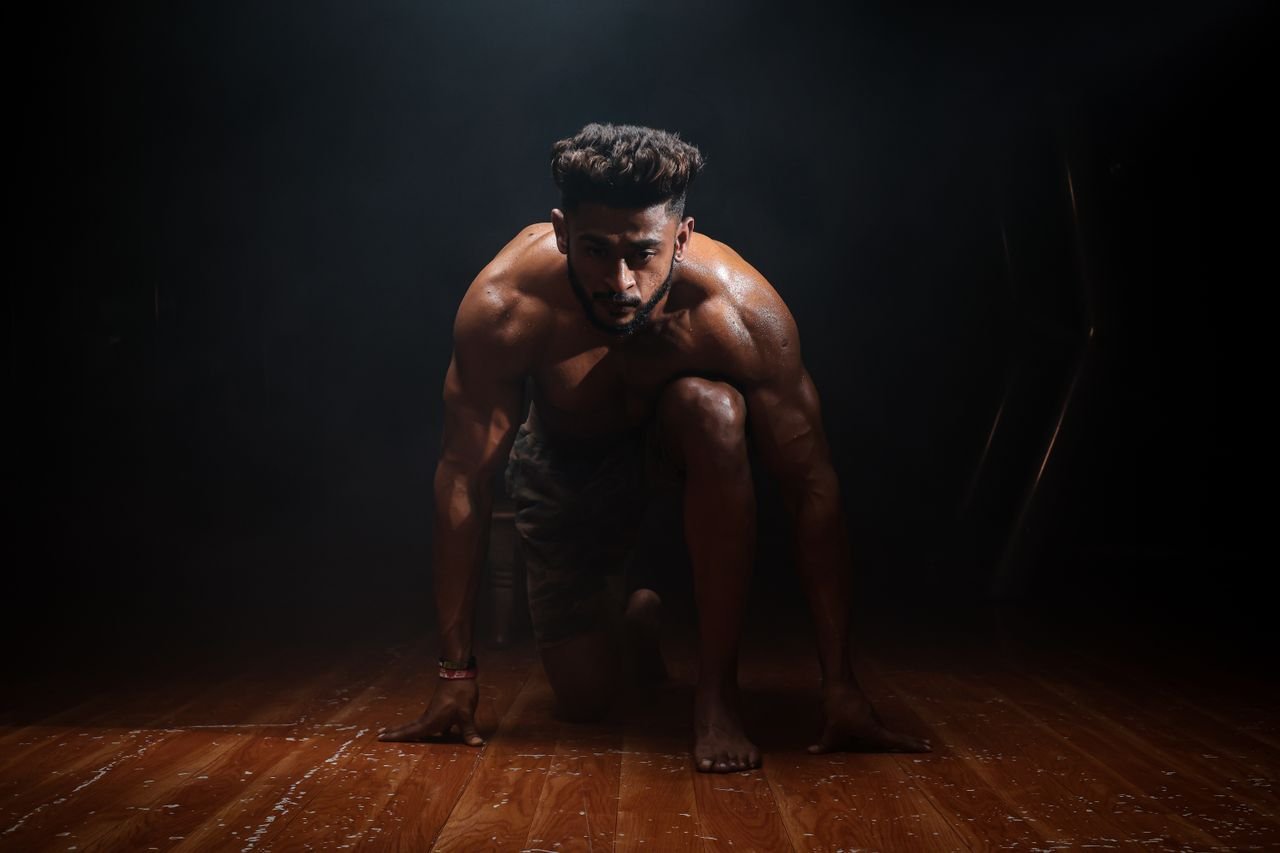 about-01 Dynamic image of a muscular man in a kneeling start position, highlighting strength and focus.