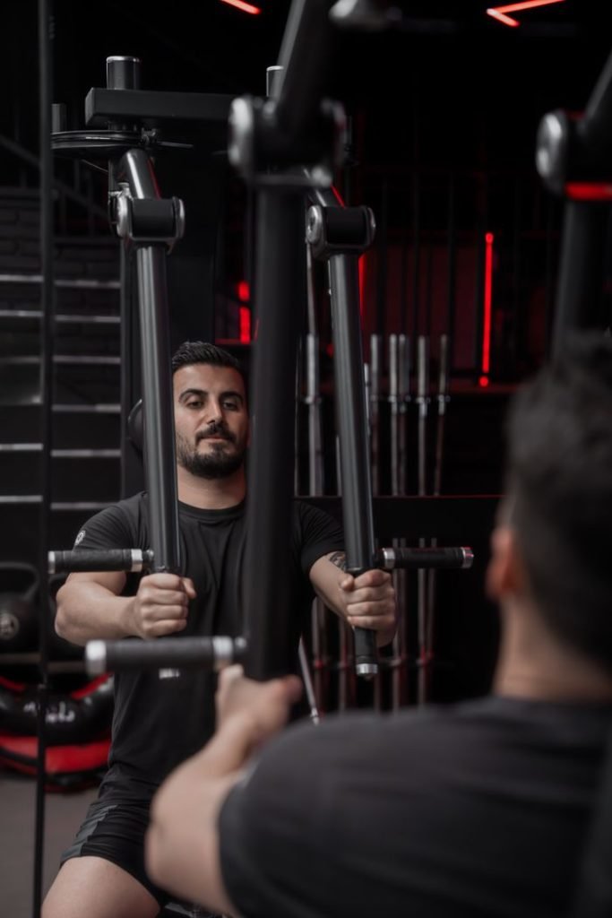 young-man-exercising-at-gym-with-fitness-equipment-29850909 Adult male focused on strength training using gym equipment. Fitness and determination concept.